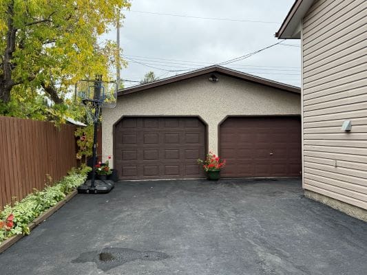 Driveway with garage and basketball hoop.