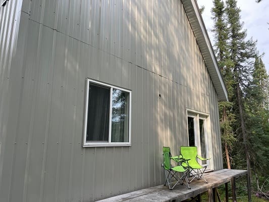 Side of house with green folding chairs.