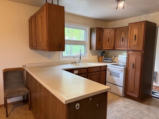 Kitchen with wooden cabinets and beige countertops.