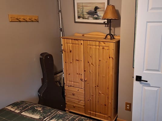 Wooden cabinet and lamp in bedroom corner.