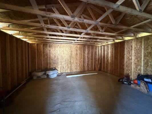 Empty wooden shed with unfinished interior.