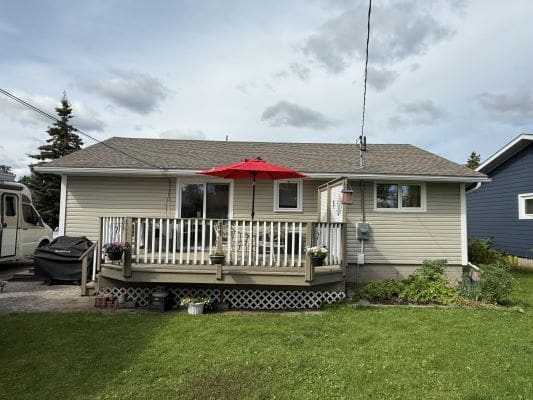 House with porch and red umbrella.
