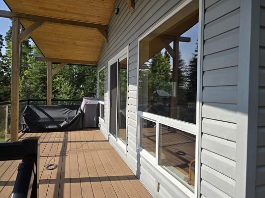 Covered patio with wooden siding and grill.