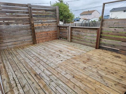 Wooden deck with fence, cloudy sky background.
