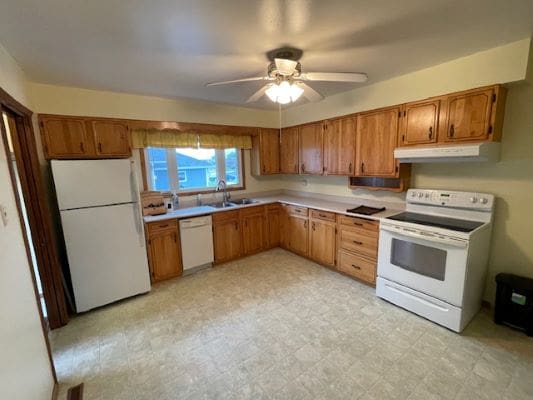 Wooden kitchen with appliances and ceiling fan.