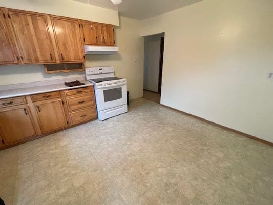 Kitchen with wooden cabinets and white stove.