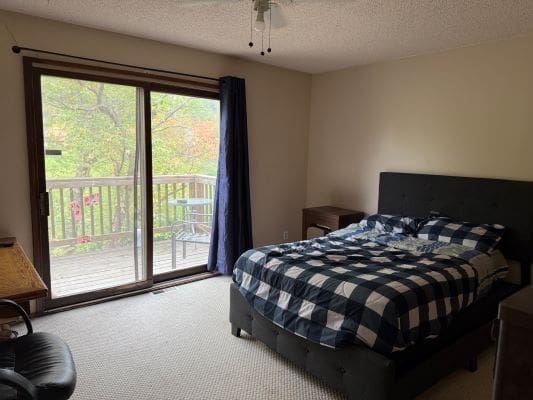 Bedroom with balcony and checkered bedspread.
