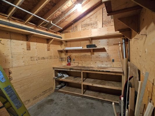 Wooden workshop with shelves and tools.