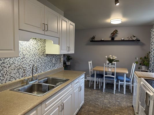 Modern kitchen with dining area and decor.