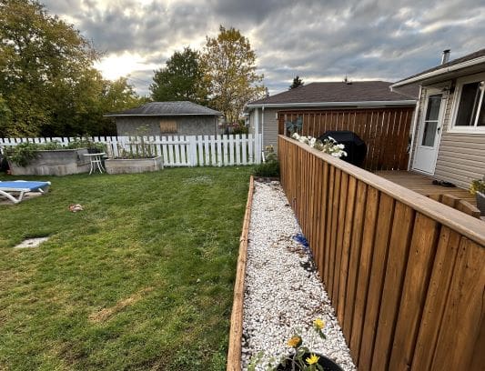 Backyard with fence and garden bed.