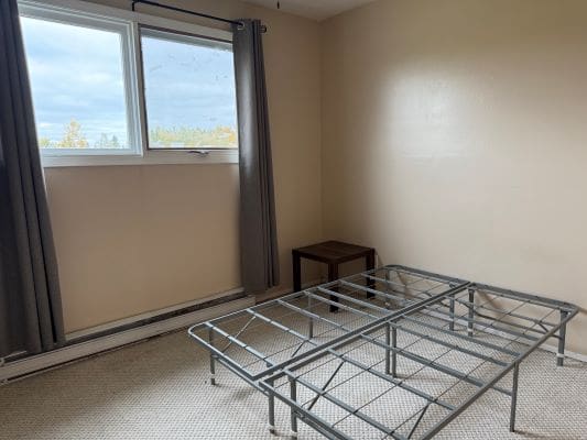 Empty room with bed frame and window.