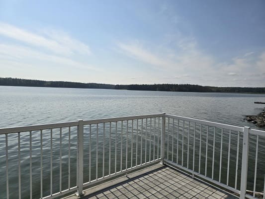 Lakeside view from white fenced balcony.