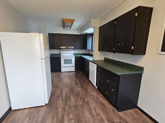 Modern kitchen with dark cabinets and appliances.