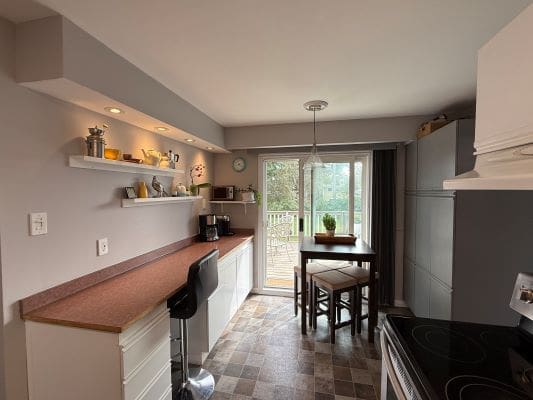 Modern kitchen with bar stools and table.