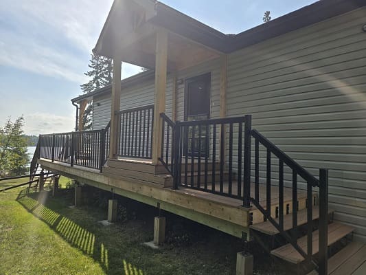House with wooden porch and black railings.