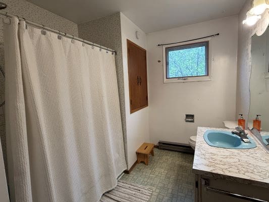 Bathroom with shower curtain and blue sink.