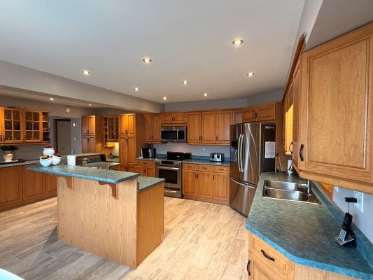 Spacious kitchen with wooden cabinets and island.