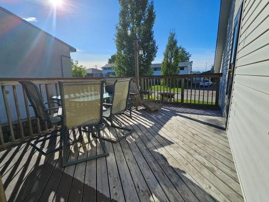 Sunny wooden deck with outdoor furniture.
