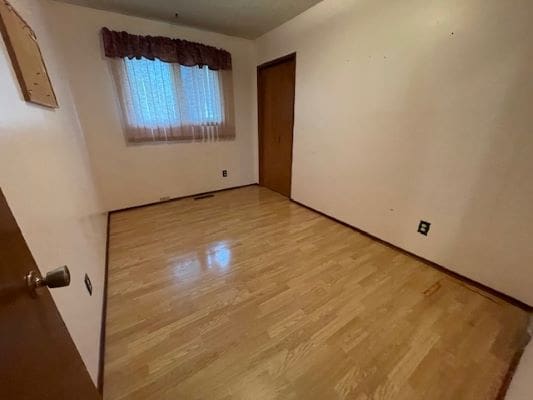 Empty room with wooden floor and window.