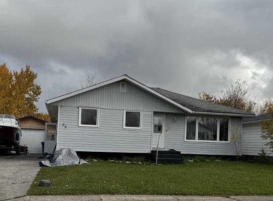 Single-story house with cloudy sky background.