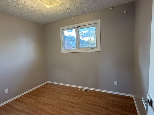 Empty room with wooden floor and window.