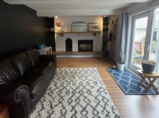 Cozy living room with fireplace and rug.