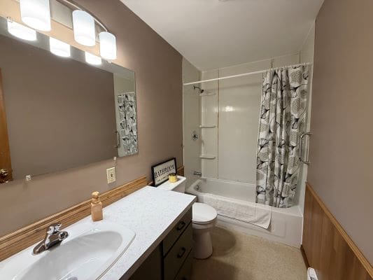 Bathroom with sink, mirror, and shower curtain.