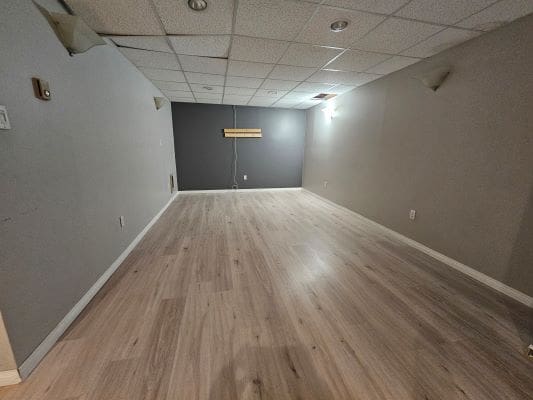 Empty room with wood flooring and lights.