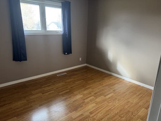 Empty room with wooden floor and window.