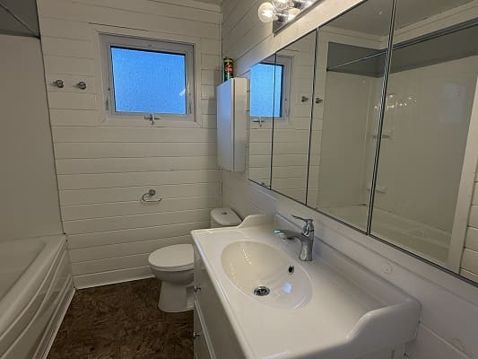 Modern bathroom with white fixtures and mirror.