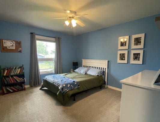 Bedroom with blue walls and green bedding.