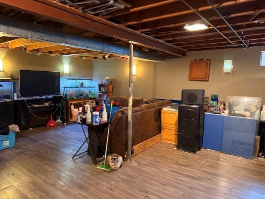 Basement living area with exposed ceiling beams.