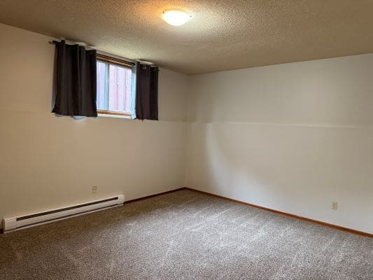 Empty room with carpet and small window.