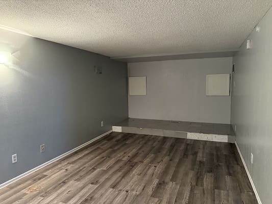 Empty room with wooden floors and stage.