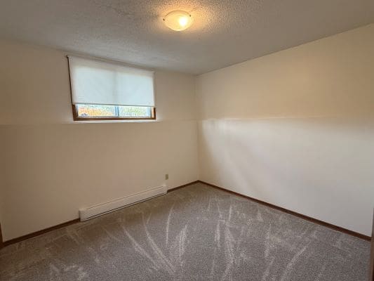 Empty room with carpet and window shade.