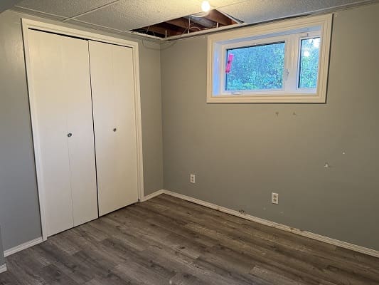 Empty room with closet and window.