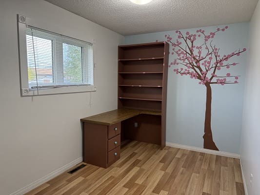 Room with desk and cherry blossom mural.
