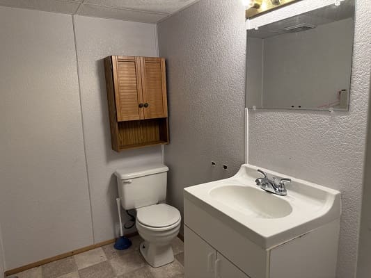 Bathroom with sink, toilet, and cabinet.
