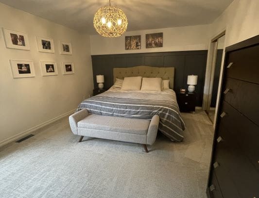 Modern bedroom with bed and decorative lighting.