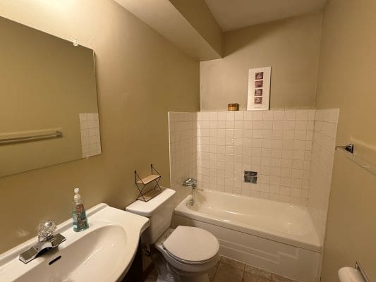 Small bathroom with bathtub and sink.