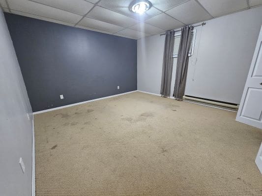 Empty room with gray accent wall, carpeted floor.