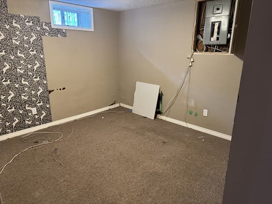 Empty room with exposed electrical panel.