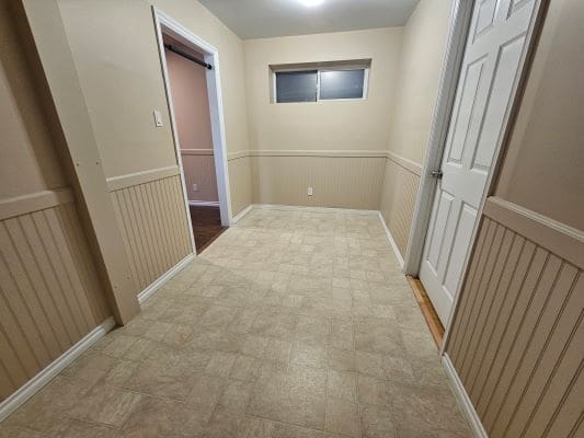 Empty beige hallway with two doors.