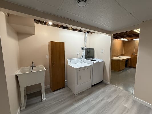 Laundry room with washer, dryer, and sink.
