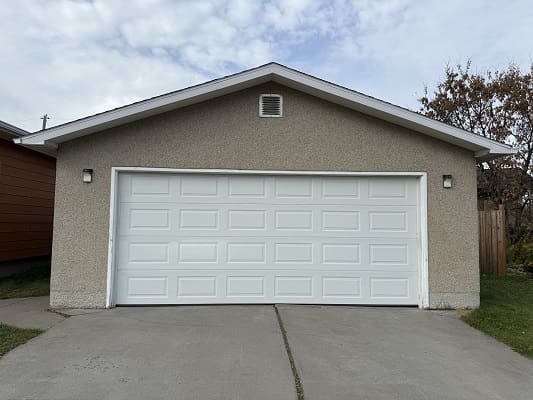 White garage door on a gray building.