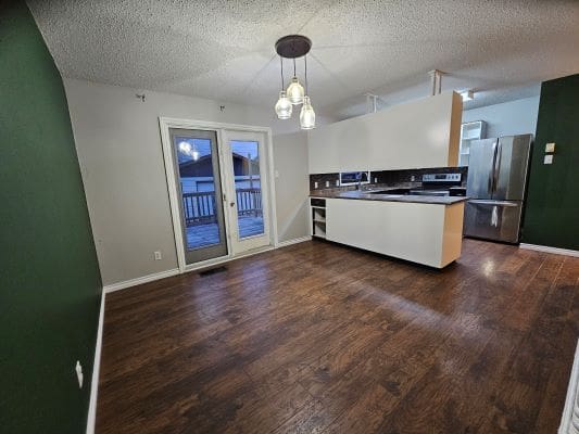 Modern kitchen with dark wood flooring.
