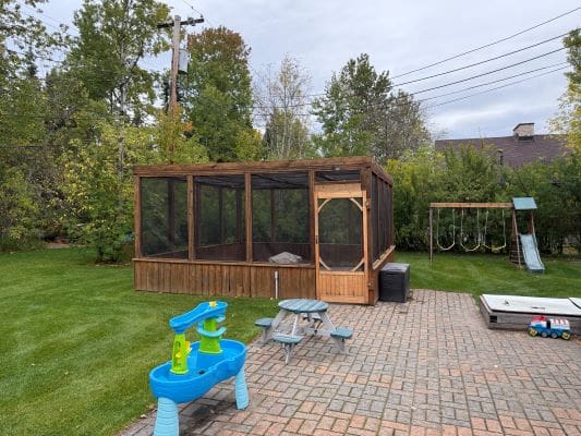 Backyard with play area and screened gazebo.