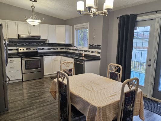 Modern kitchen and dining area with table.