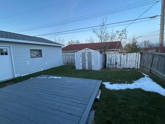 Backyard with shed and wooden deck.