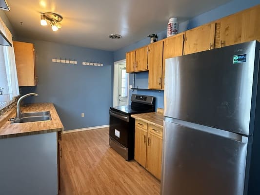 Modern kitchen with wooden cabinets and appliances.